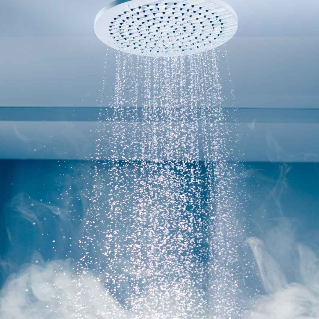 pommeau de douche avec de l'eau chaude qui coule